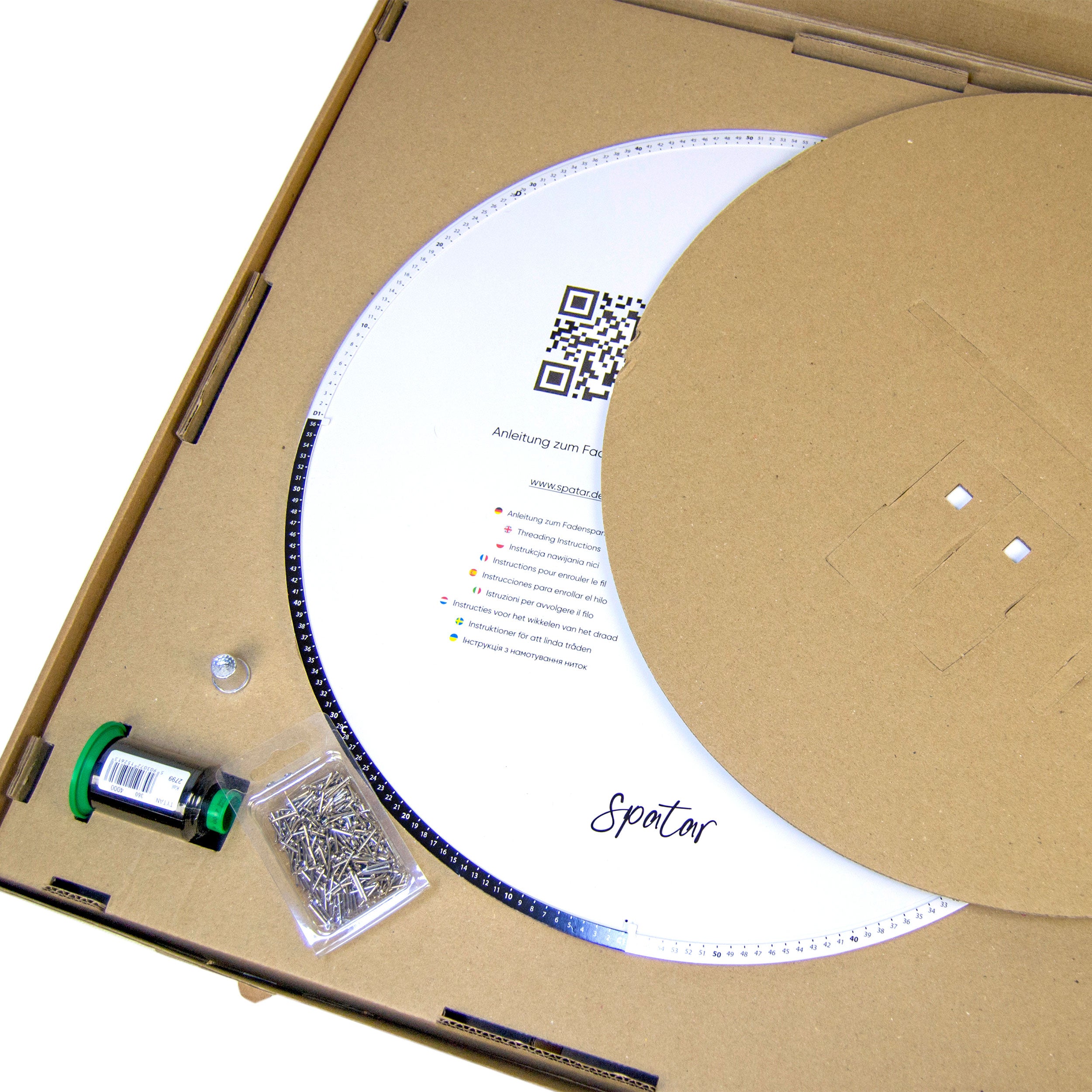 Open String Art DIY kit showing circular base, nails, thread, and instruction insert inside the box