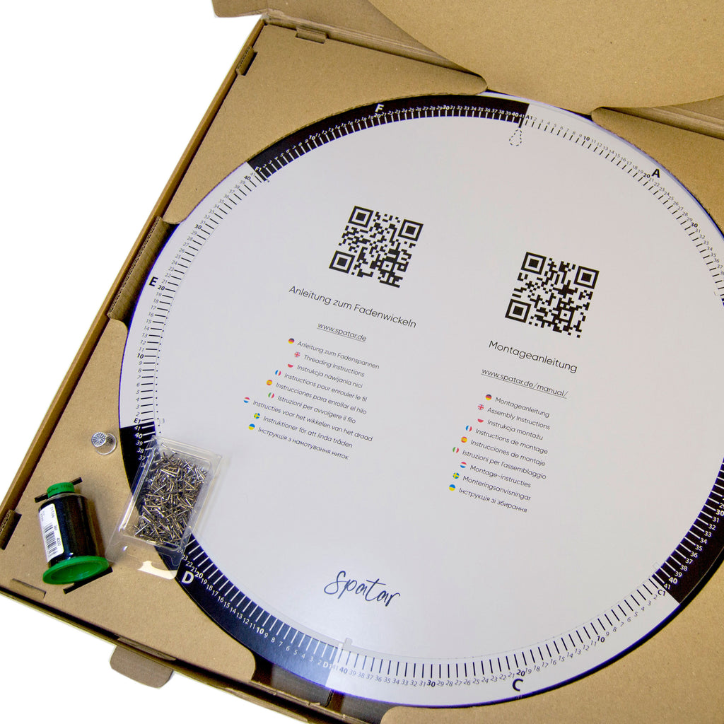 Open String Art DIY kit displaying circular base, printed instruction disc, nails, and thread inside the box