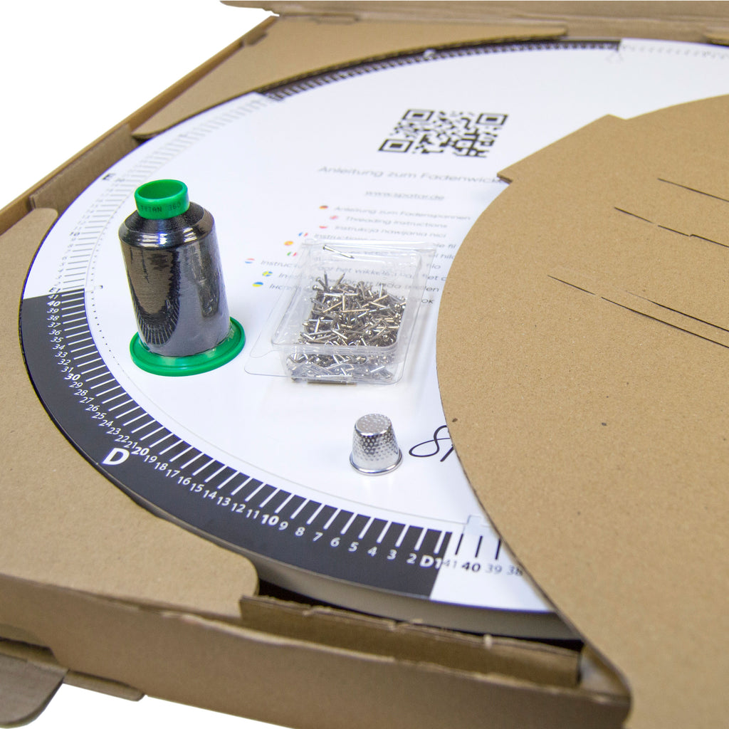 Close-up of String Art DIY kit materials including black thread spool, nails, and circular base